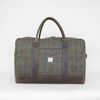 Detailansicht der braunen Harris Tweed® Reisetasche mit Ledergriffen.